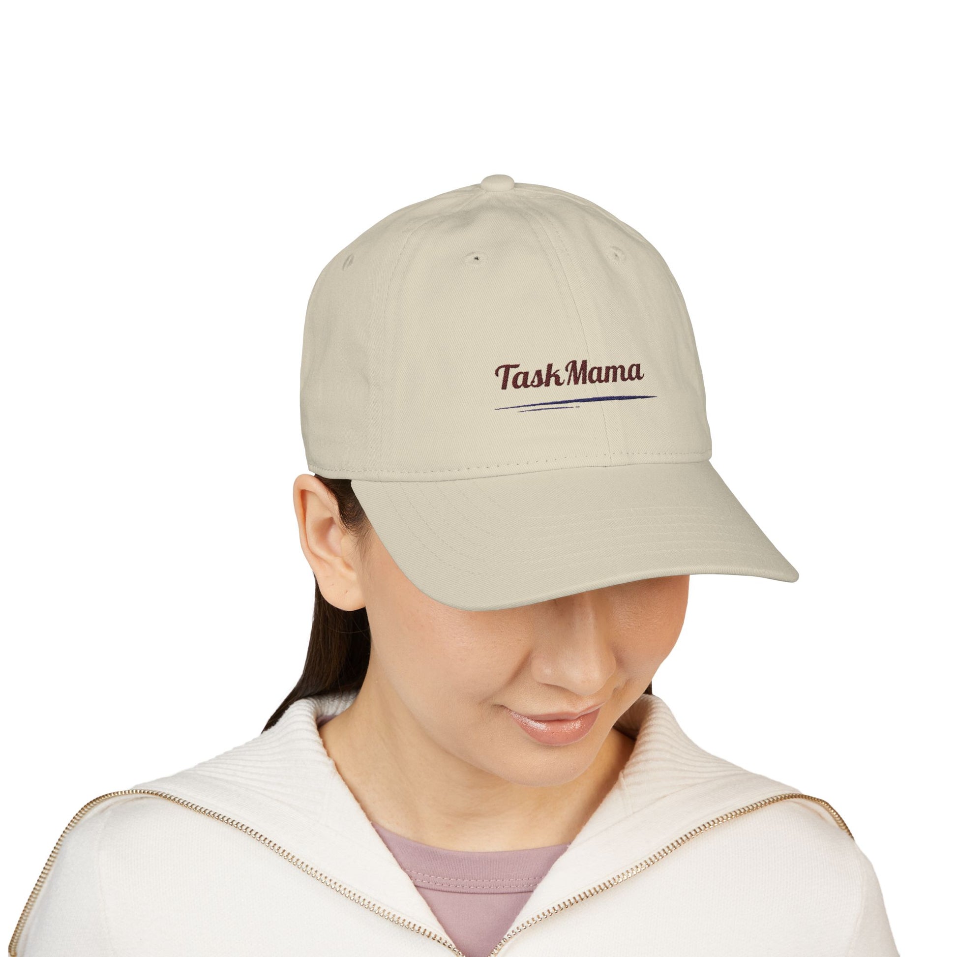 Person wearing a beige cap with 'Task Mama' text on a white background