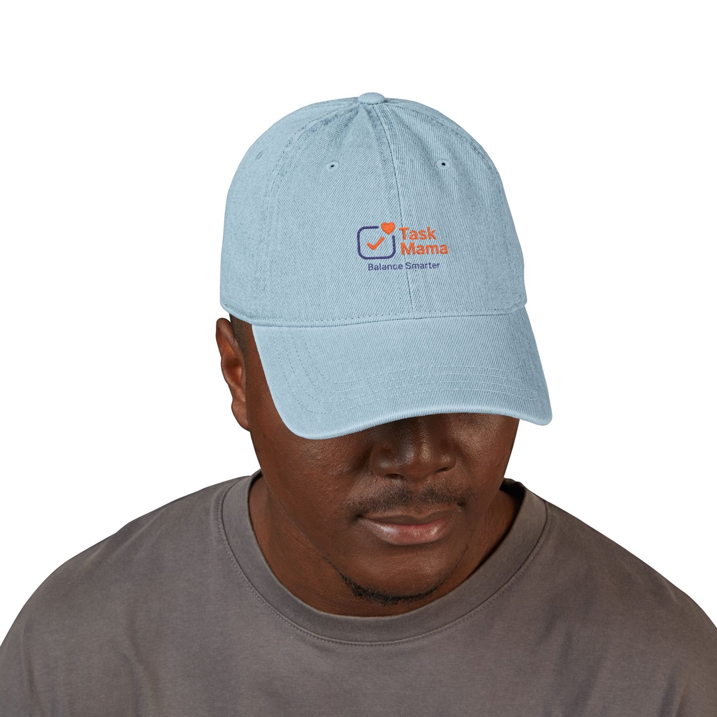 Man wearing a light blue cap with 'Task Mama' logo on a white background