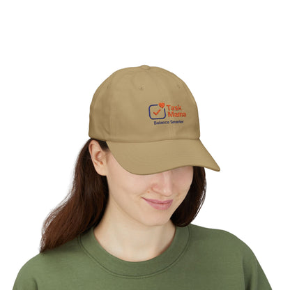 Person wearing a tan cap with a logo on a white background