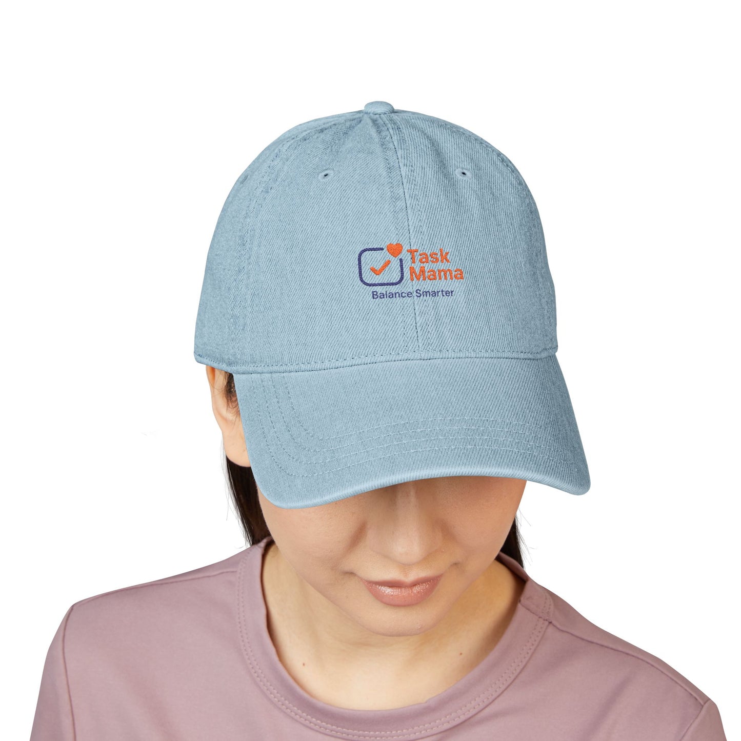 Light blue cap with 'Task Mama' logo worn by a person on a white background