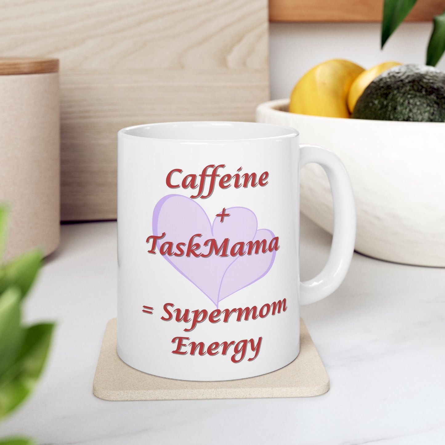 White mug with text 'Caffeine + TaskMama = Supermom Energy' on a wooden coaster.