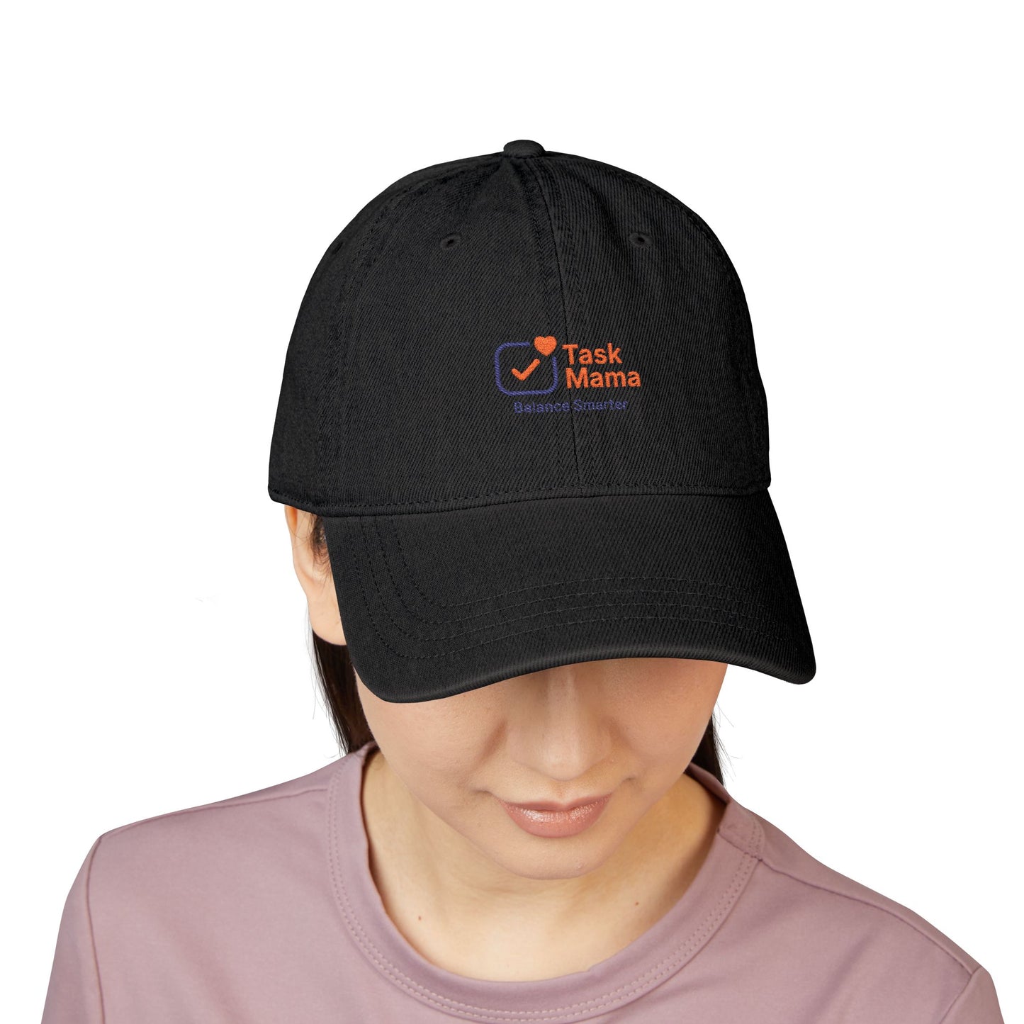 Black cap with 'Task Mama' logo worn by a person on a white background