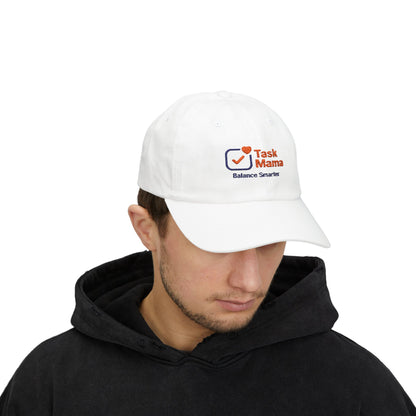 Person wearing a white cap with 'Task Mama' logo on a white background