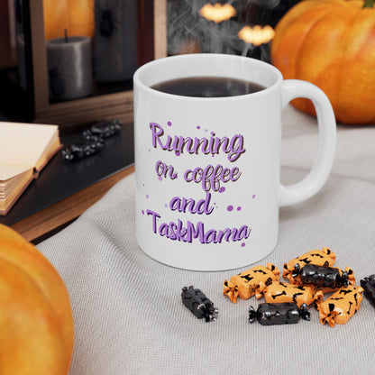 White mug with 'Running on coffee and TaskMama' text, surrounded by Halloween-themed treats and pumpkins.