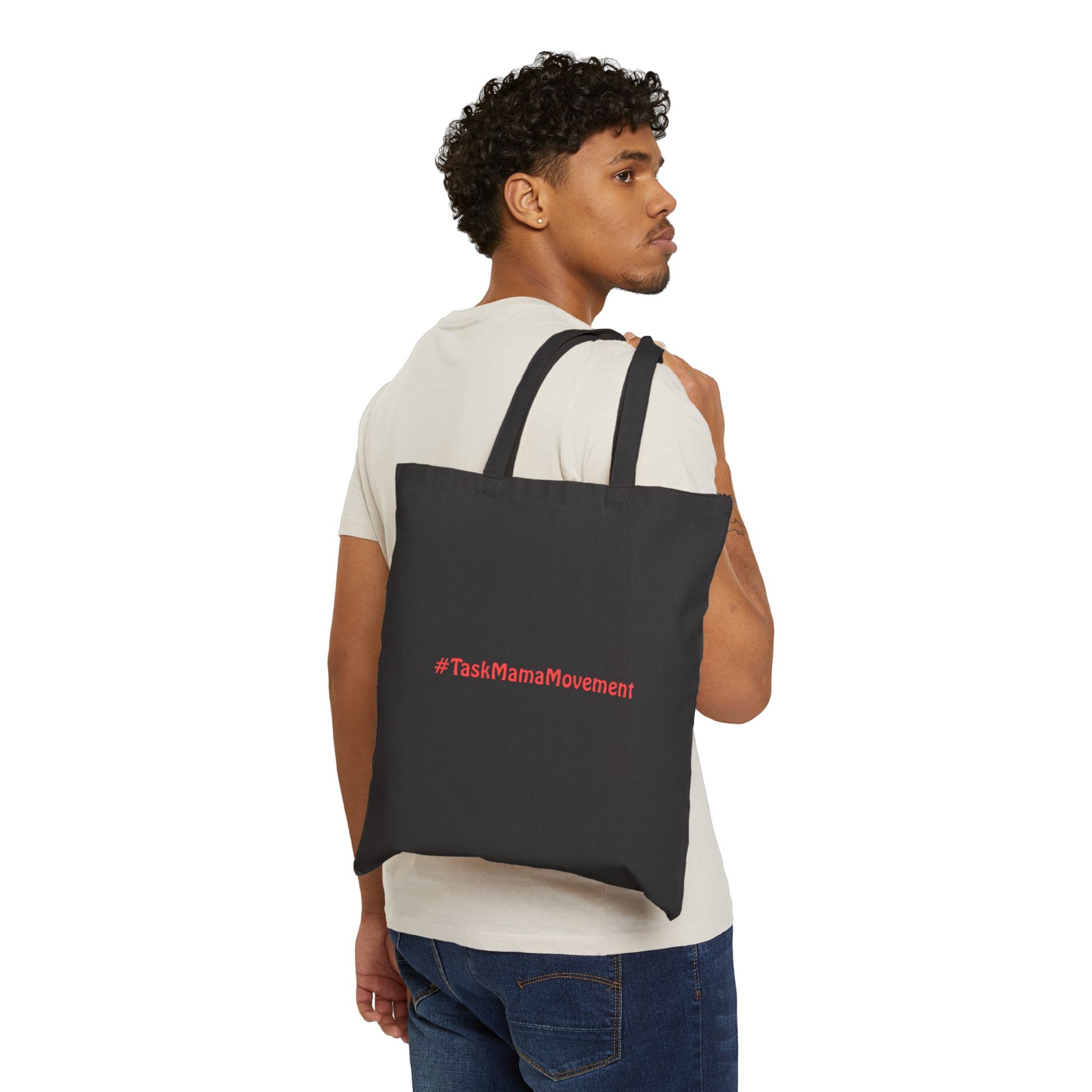 Man carrying a black tote bag with '#TaskMamaMovement' text on a white background