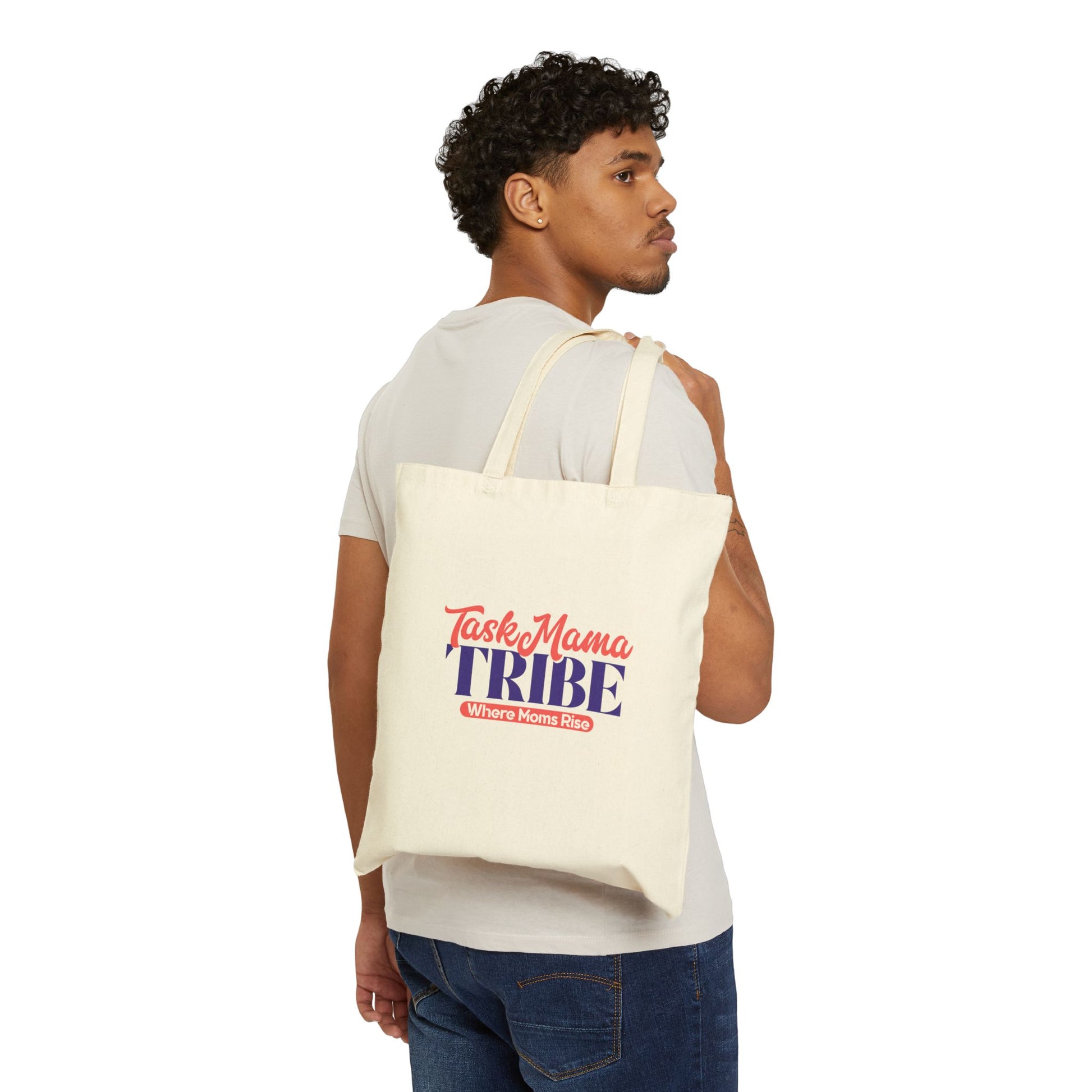 Man carrying a tote bag with 'Tasty Mama Tribe' text on a white background