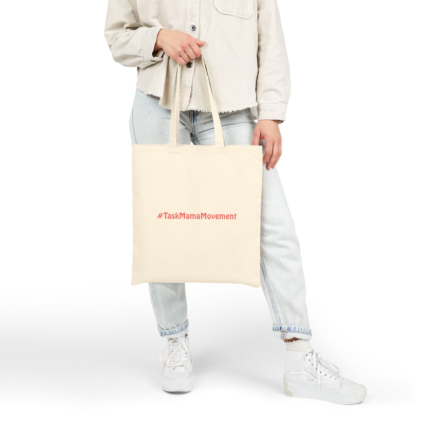 Person holding a beige tote bag with '#TaskMamaMovement' text on a white background